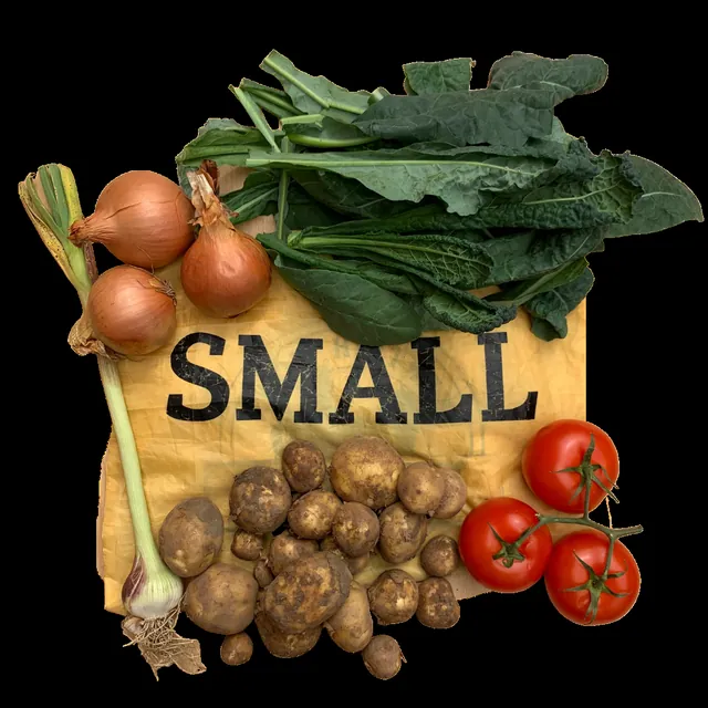 The contents of a Small bag laid out: cavolo nero, potatoes, onions, tomatoes and garlic
