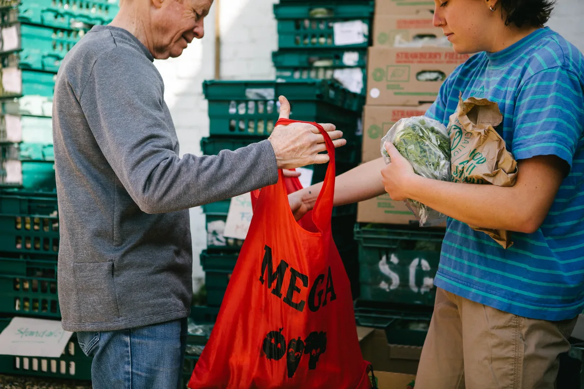A member collecting their red Mega bag of veg